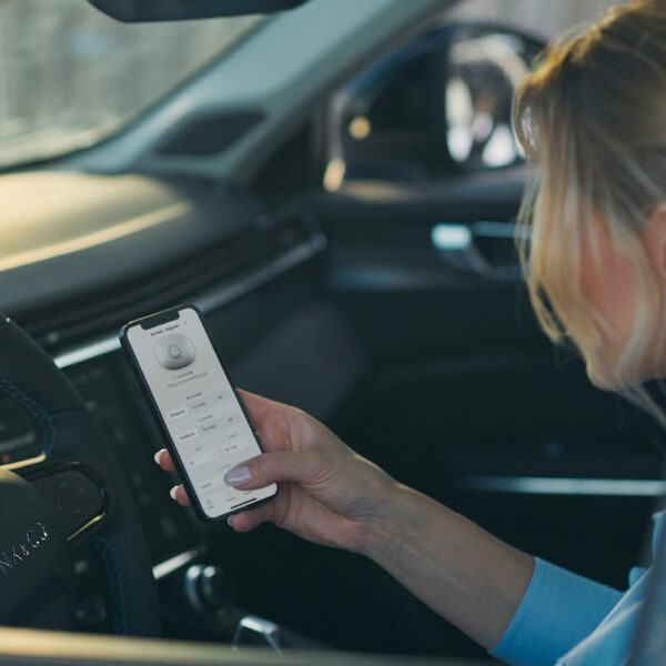 Kvinna använder charge amps halo app i elbil